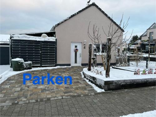 a house with snow on the ground in front of it at Gemütliches Eifeler Gästehäuschen in Nettersheim