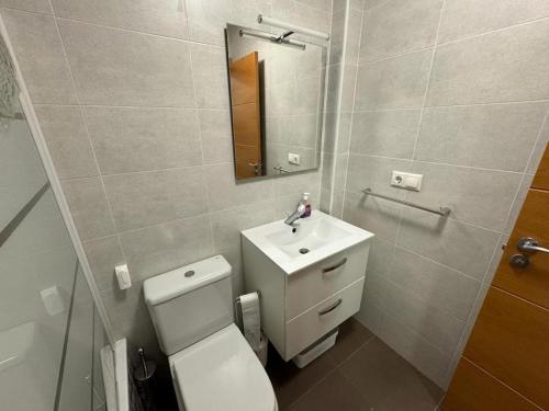 uma casa de banho com um WC, um lavatório e um espelho. em global 69 em Salobreña