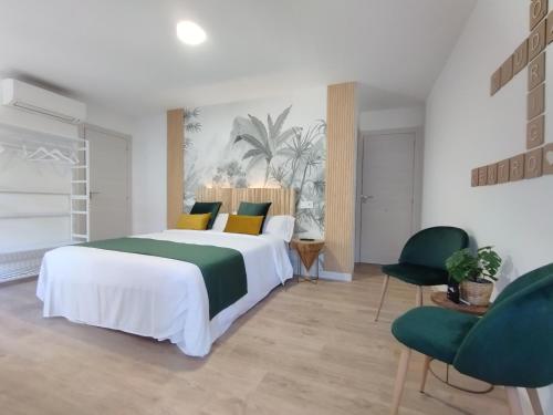a bedroom with a large bed and two chairs at Ciudad Rodrigo Centro in Ciudad-Rodrigo
