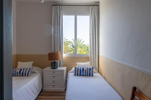 two beds in a room with a window at Finca San Diego with Pool & Wifi in La Matanza de Acentejo