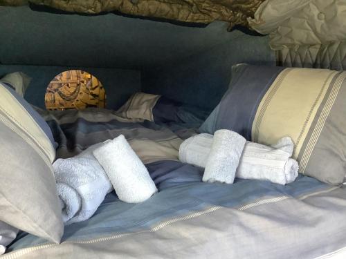 a bed with towels on top of it at Haelarcher Helicopter Glamping in Helston