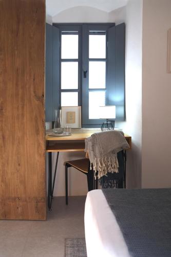 a bedroom with a desk with a bed and a window at Arta Hydra in Hydra