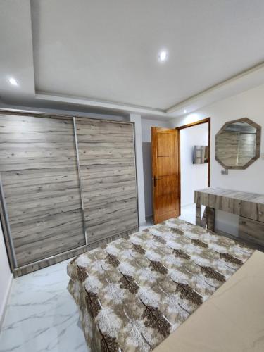 a bedroom with a large bed and a large sliding door at résidence el yassamine in Bizerte