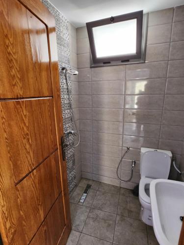 baño con aseo y lavabo y ventana en résidence el yassamine, en Bizerte