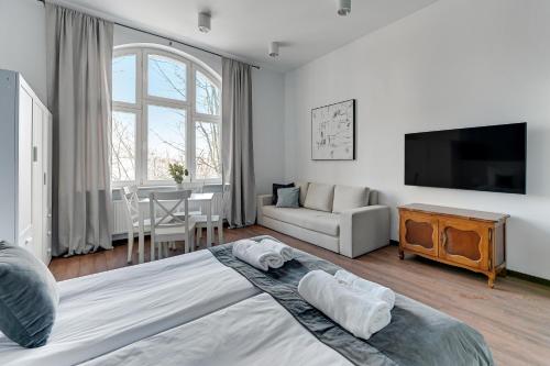 a bedroom with a large bed and a living room at Downtown Apartments Sopot Chopina Seaside in Sopot
