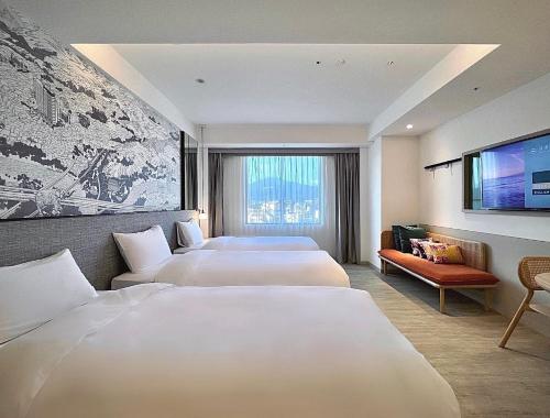 台北市にあるBoutech JianTan Hotelのベッド3台、薄型テレビが備わるホテルルームです。