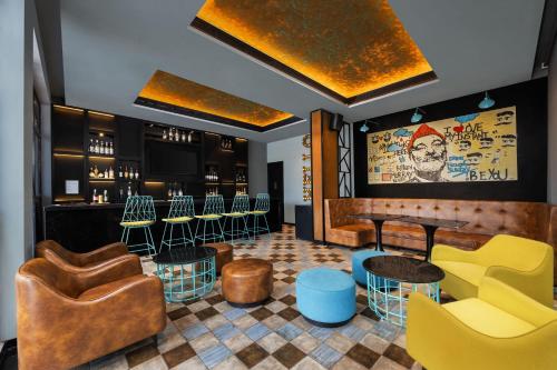 a bar with yellow and blue chairs and tables at Fairfield by Marriott Sriperumbudur in Sriperumbudur