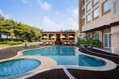 a swimming pool in front of a building at Fairfield by Marriott Sriperumbudur in Sriperumbudur