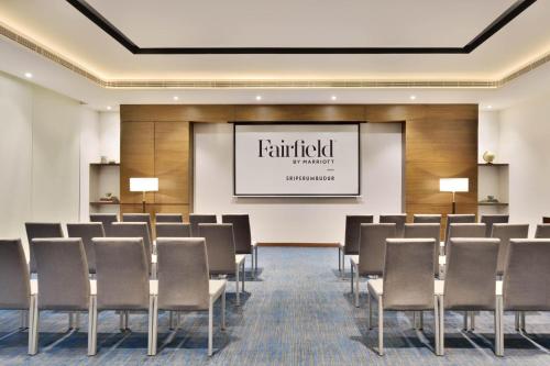 a conference room with chairs and a projection screen at Fairfield by Marriott Sriperumbudur in Sriperumbudur