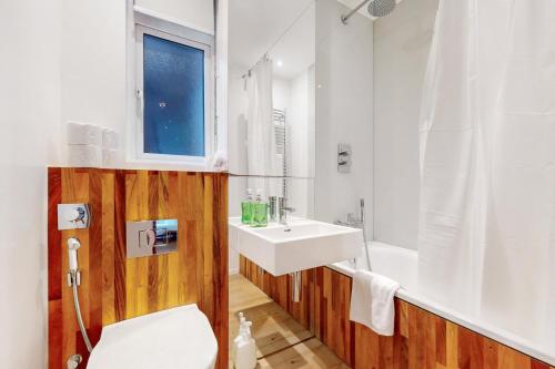 a bathroom with a sink and a toilet and a tub at Modern 2 Bed Apartment near Acton Central Tube Station - Sleeps 4 in London