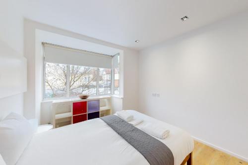 a white bedroom with a bed and a window at Modern 2 Bed Apartment near Acton Central Tube Station - Sleeps 4 in London