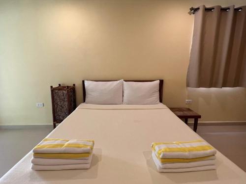 a bedroom with a large bed with towels on it at Amor Double Room with Swimming Pool in Boracay