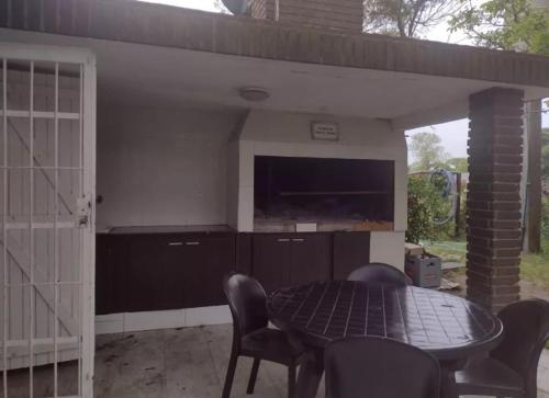 patio con mesa, sillas y TV en Casa en Playas del Sur en Mar del Plata