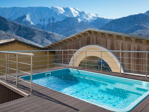a swimming pool on top of a house with mountains at ibis Styles Krasnaya Polyana in Estosadok