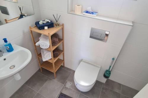 La salle de bains est pourvue de toilettes blanches et d'un lavabo. dans l'établissement וגאס, à Bayit Wegan