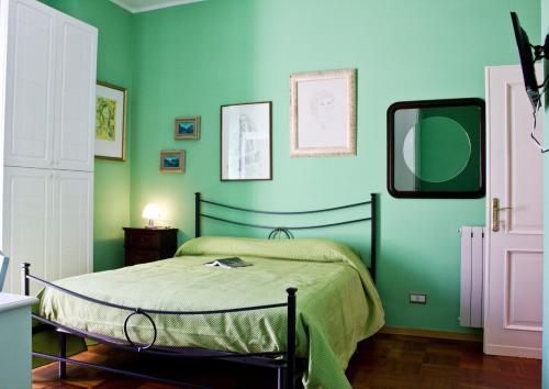 a bedroom with a bed with green walls and a mirror at La Bertina in Montefiascone