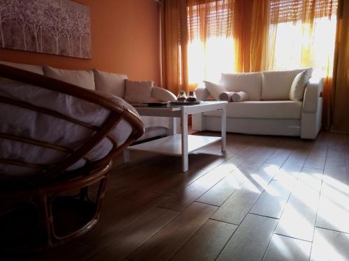Apartment Puhov Zadar في زادار: غرفة معيشة مع أريكة بيضاء وطاولة