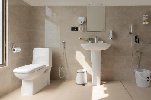 a bathroom with a toilet and a sink at Hotel Dralha in Thimphu