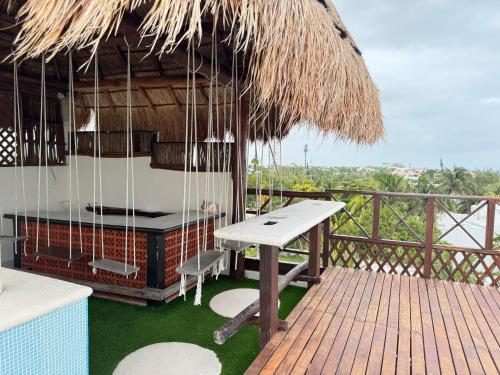a hut with a table and a bench on a deck at Suites Valentina in Puerto Morelos