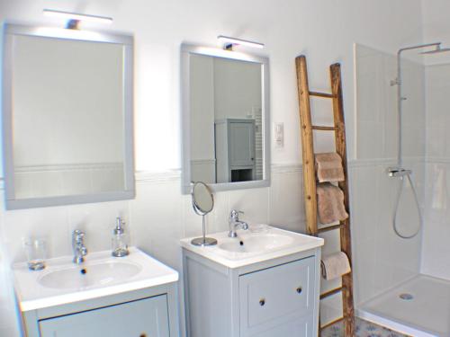 W łazience znajdują się 2 umywalki, prysznic i lustro. w obiekcie Le Domaine des Cyclamens w mieście Verneuil-sur-Indre
