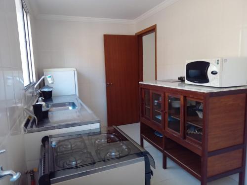 a kitchen with a sink and a microwave on a counter at Antonia Haddad in Lorena