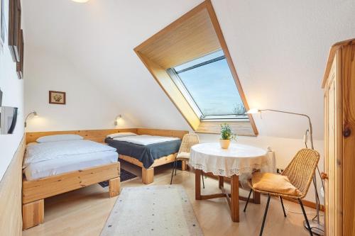 a room with two beds and a table and a window at Haus Erna am Deister in Barsinghausen