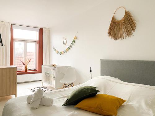 ein Schlafzimmer mit einem Bett mit gelben und grünen Kissen in der Unterkunft Charming house in city centre Oud-Beijerland in Oud-Beijerland