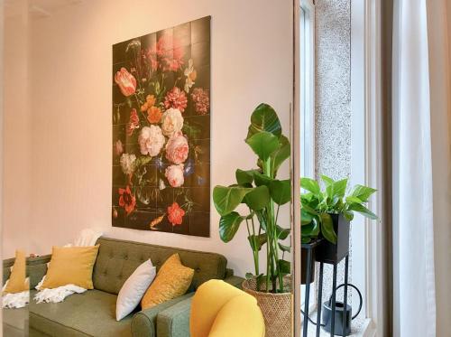 a living room with a couch and a painting on the wall at Charming house in city centre Oud-Beijerland in Oud-Beijerland