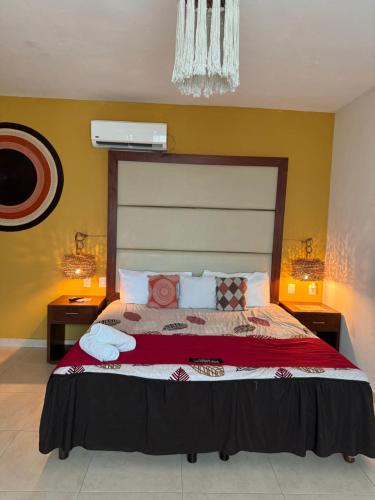 a bedroom with a large bed with two night stands at Suites Valentina in Puerto Morelos