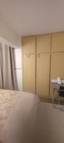 - une chambre avec un lit, une table et des armoires dans l'établissement 2 Chambre Arena - La Chapelle, à Paris