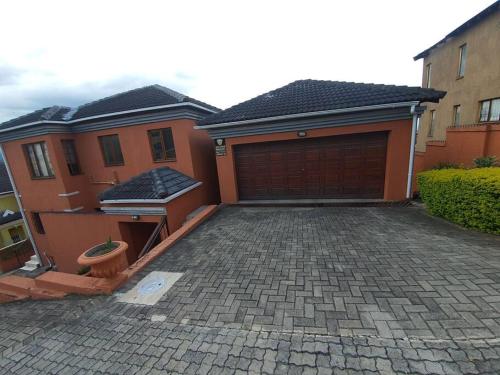 a house with a brick driveway with a garage at Dumi Place in Mataffin