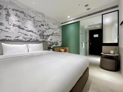 a bedroom with a white bed and a green wall at Boutech JianTan Hotel in Taipei