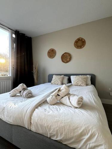 a bedroom with a large bed with towels on it at Stads charme & comfort Tilburg in Tilburg