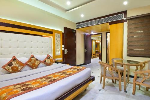 a bedroom with a bed and a table and a chair at Hotel Hari Piorko Grand - New Delhi Railway Station in New Delhi