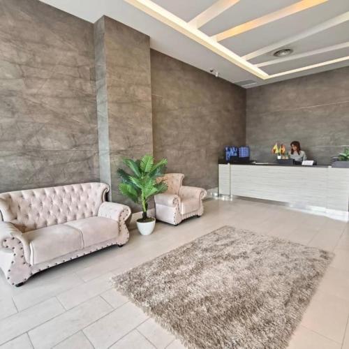 a living room with two couches and a rug at SUMMER SUITES APARTMENT CASETTA HOMESTAY 1 at Kota Samaraham Kuching in Kota Samarahan