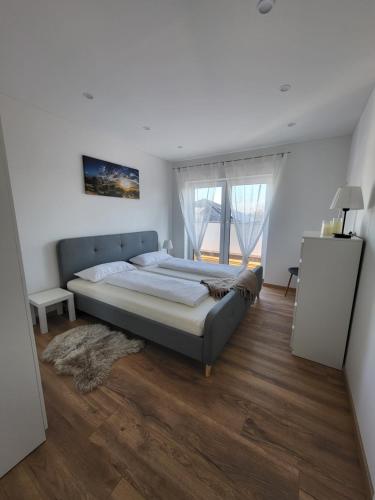 a bedroom with a large bed and a large window at Apartment Nia mit Sauna und Whirlpool in Euskirchen