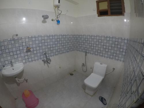 a bathroom with a toilet and a sink at 4 KING SIZE BEDROOM DUPLEX VILLA in Hyderabad