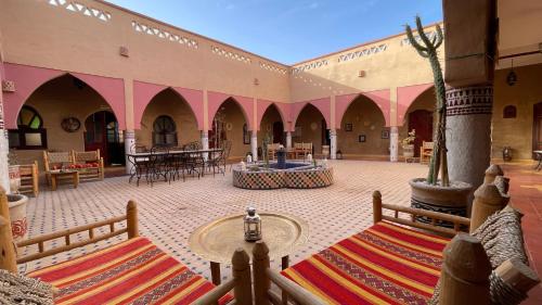 einen Innenhof mit Tischen und Stühlen in einem Gebäude in der Unterkunft RIAD dar POUBLANC in Merzouga