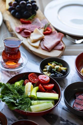 una mesa con platos y cuencos de verduras y carne en Mövenpick Hotel Istanbul Asia Airport, en Estambul