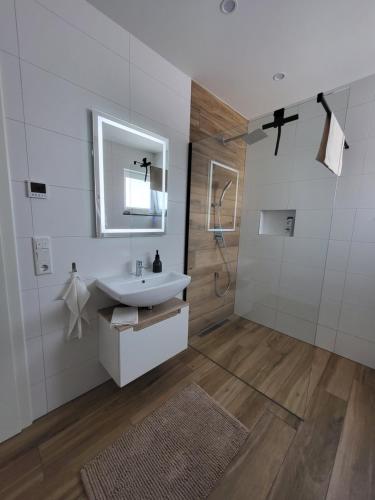 a white bathroom with a sink and a shower at Apartment Nia mit Sauna und Whirlpool in Euskirchen