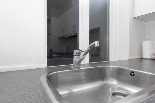 - un évier en acier inoxydable dans une cuisine avec un miroir dans l'établissement Come Stay in Aarhus - Close to everything 4 people, à Aarhus
