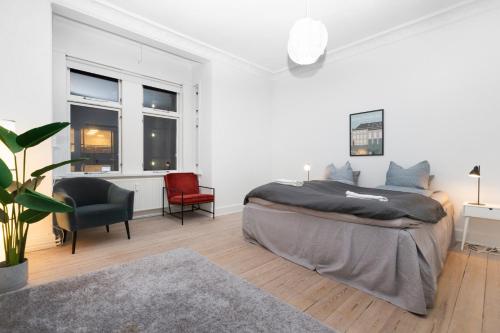 1 dormitorio blanco con 1 cama grande y 2 sillas en Come Stay in Aarhus - Close to everything 4 people en Aarhus