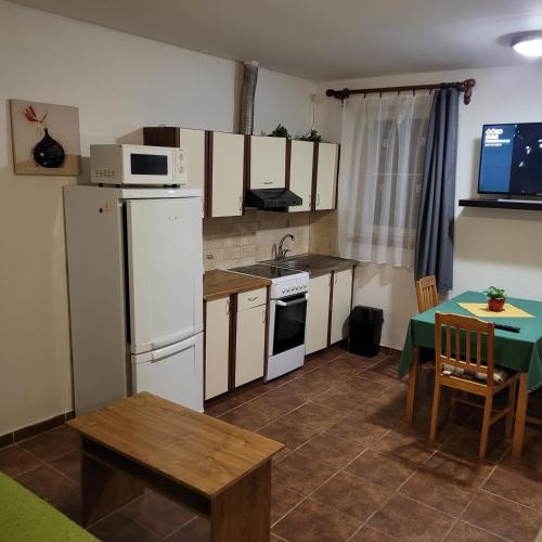 a kitchen with a white refrigerator and a table at Apartmány Hartaclub in Vrchlabí