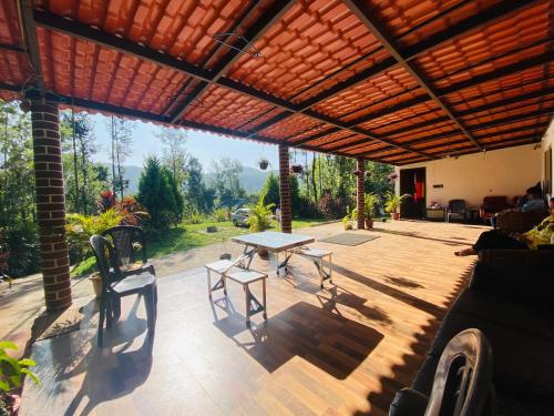 a patio with a table and chairs on it at Timber leaf stay in Avathi