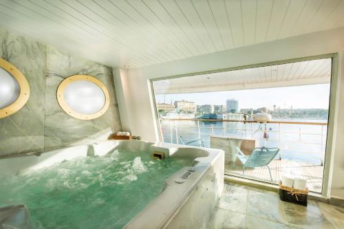 a bathroom with a bath tub with a large window at M/Y ALYSSA - 4 or 7 Nights From Luxor each Monday and 3 or 7 Nights From Aswan each Friday in Luxor