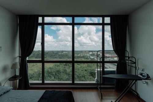 a bedroom with a large window with a view at SUMMER SUITES APARTMENT CASETTA HOMESTAY 1 at Kota Samaraham Kuching in Kota Samarahan