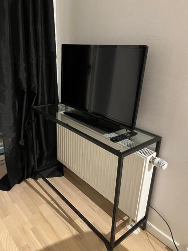 un televisor en una mesa de cristal con un televisor en él en Amager Studio, en Copenhague