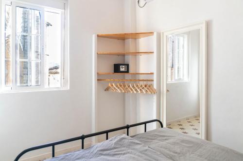 een slaapkamer met een bed en een spiegel bij Azafran Jerez apartamentos in Jerez de la Frontera