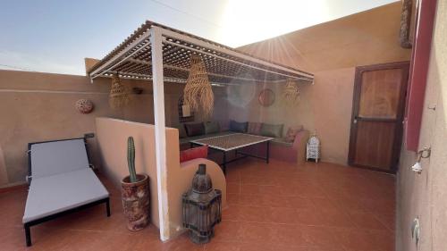 una habitación con una mesa y un banco en una casa en RIAD dar POUBLANC en Merzouga