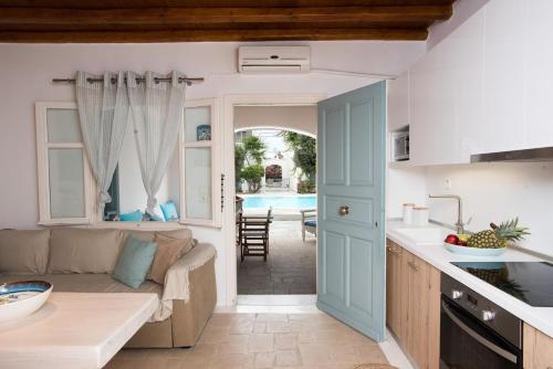 una cucina e un soggiorno con divano e tavolo di Mykonian Style Pool Houses a Ornos